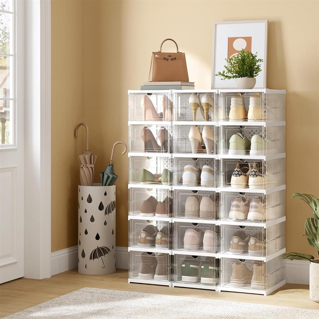 Transparent shoe storage boxes are stacked in a room, with umbrellas in a decorative holder and a potted plant on top.