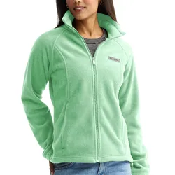A woman wearing a light green fleece jacket with a zip front and a small logo on the chest, over a striped shirt and jeans.