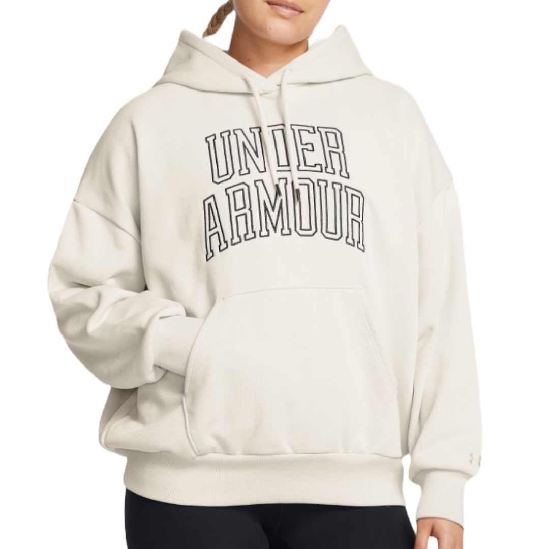 Cream-colored oversized hoodie with \“UNDER ARMOUR\“ in bold black letters across the chest. Features a front kangaroo pocket, adjustable drawstrings, and ribbed cuffs and hem.