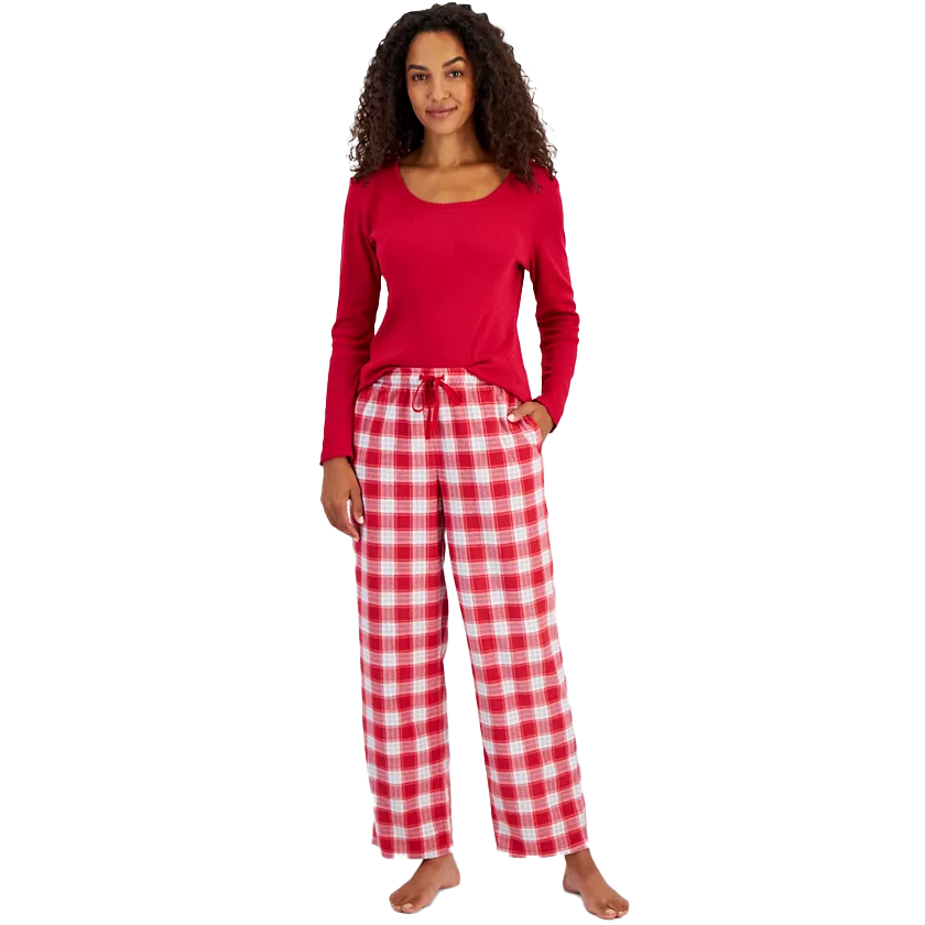 A woman wearing a red long-sleeve top and checkered red and white pajama pants.