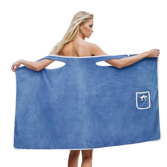 A woman is using a blue wearable towel with armholes and pocket detailing, offering a hands-free drying experience.