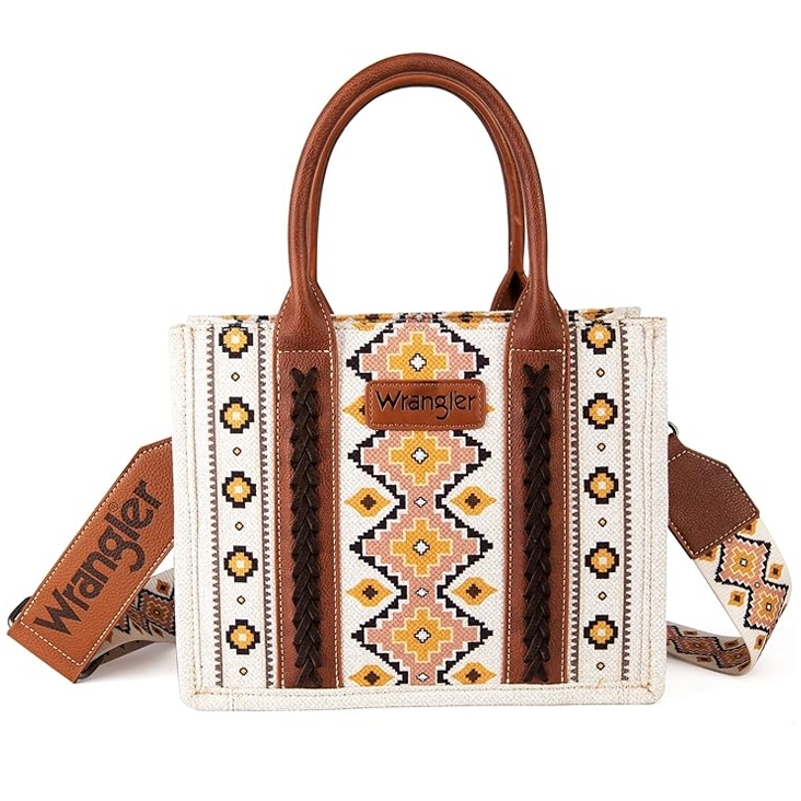 Wrangler Montana West Tote features a vibrant southwestern pattern with earthy tones, leather accents, braided details, and sturdy handles. It includes a wide adjustable shoulder strap with the Wrangler logo.