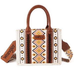 Wrangler Montana West Tote features a vibrant southwestern pattern with earthy tones, leather accents, braided details, and sturdy handles. It includes a wide adjustable shoulder strap with the Wrangler logo.