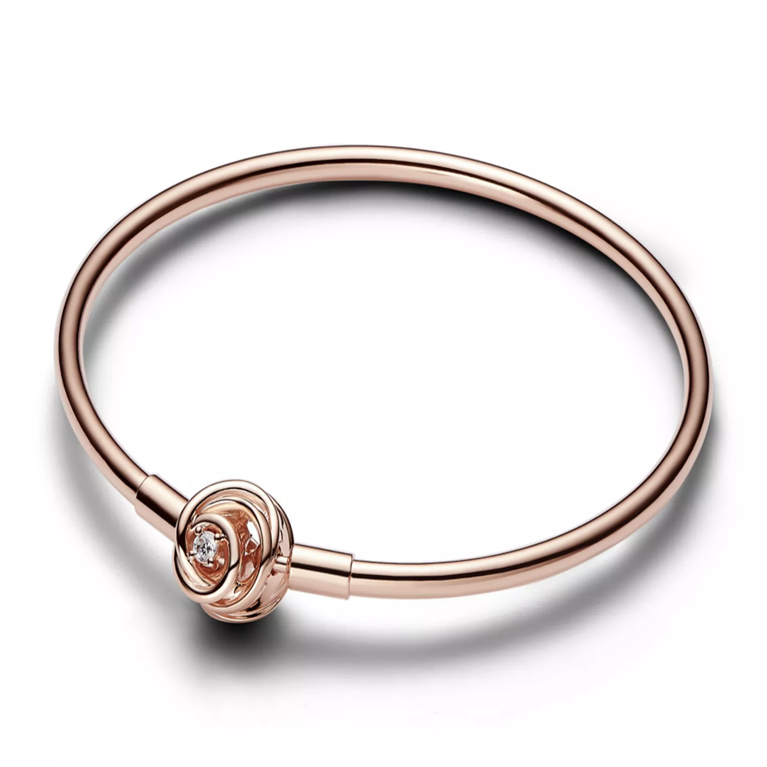 A rose gold bracelet featuring a central decorative knot with an embedded diamond-like stone, set on a sleek, closed-loop band.