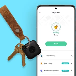 A set of keys attached to a Tile Bluetooth tracker, alongside a smartphone screen displaying the Tile app interface for locating the keys.