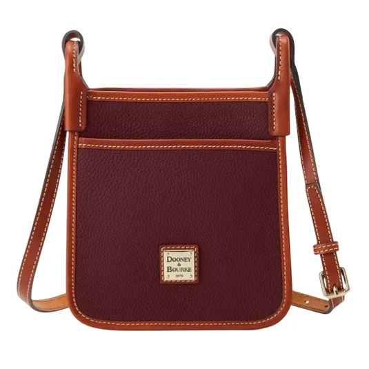 A burgundy crossbody bag with brown leather trim and adjustable strap, featuring a front pocket and a Dooney & Bourke logo.
