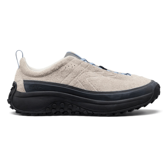 A beige sneaker with a textured upper, black sole, and blue accents. It features a rugged, traction-oriented outsole for outdoor activities.