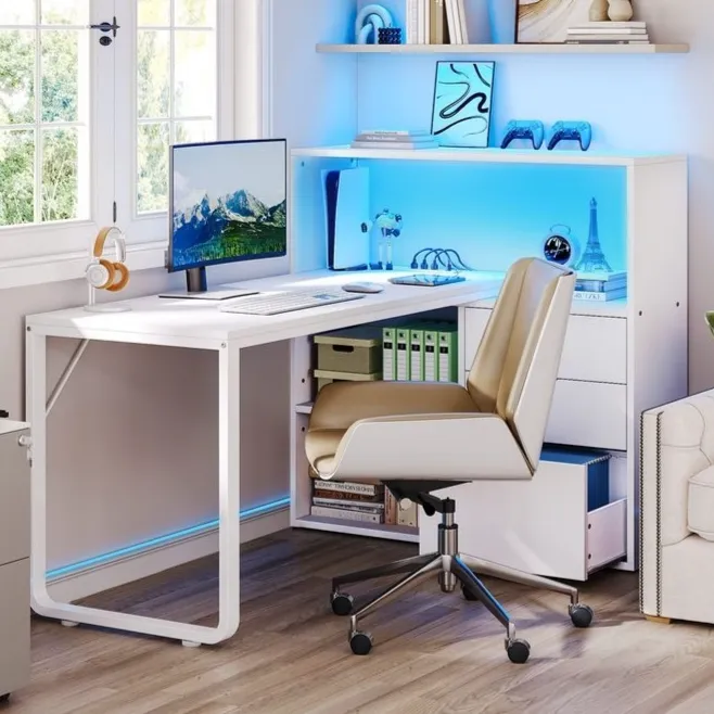 Modern home office setup with a white desk, computer monitor, tan office chair, and a shelving unit with blue LED lighting. Accessories include headphones, a printer, books, and decorative items like a mini Eiffel Tower and toy car.