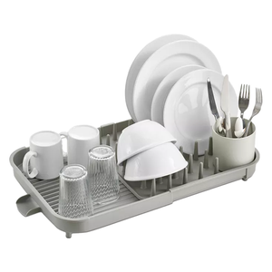 Expandable dish drying rack with a gray base holding white plates, bowls, mugs, and clear glasses. Includes a cutlery compartment with forks, spoons, and knives.