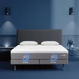Smart adjustable mattress with two firmness levels: 45 (softer) and 60 (firmer), set against a modern blue bedroom with two pillows and a minimalistic design.