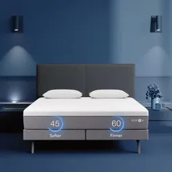 Smart adjustable mattress with two firmness levels: 45 (softer) and 60 (firmer), set against a modern blue bedroom with two pillows and a minimalistic design.