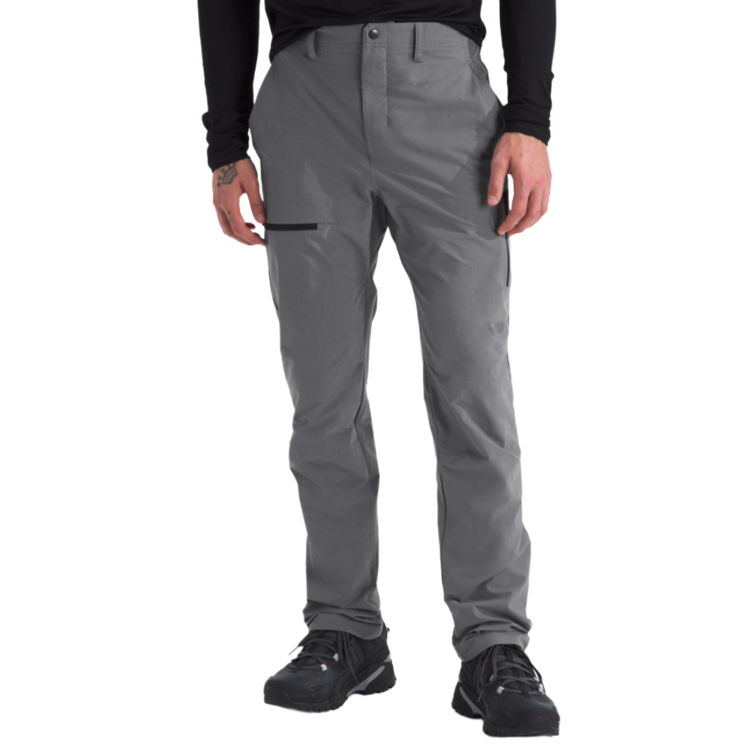 Gray hiking pants with a slim fit, button closure, and a zippered side pocket, paired with black athletic shoes.