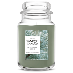 Yankee Candle with \“Silver Sage & Pine\“ scent in a large glass jar with a green wax.