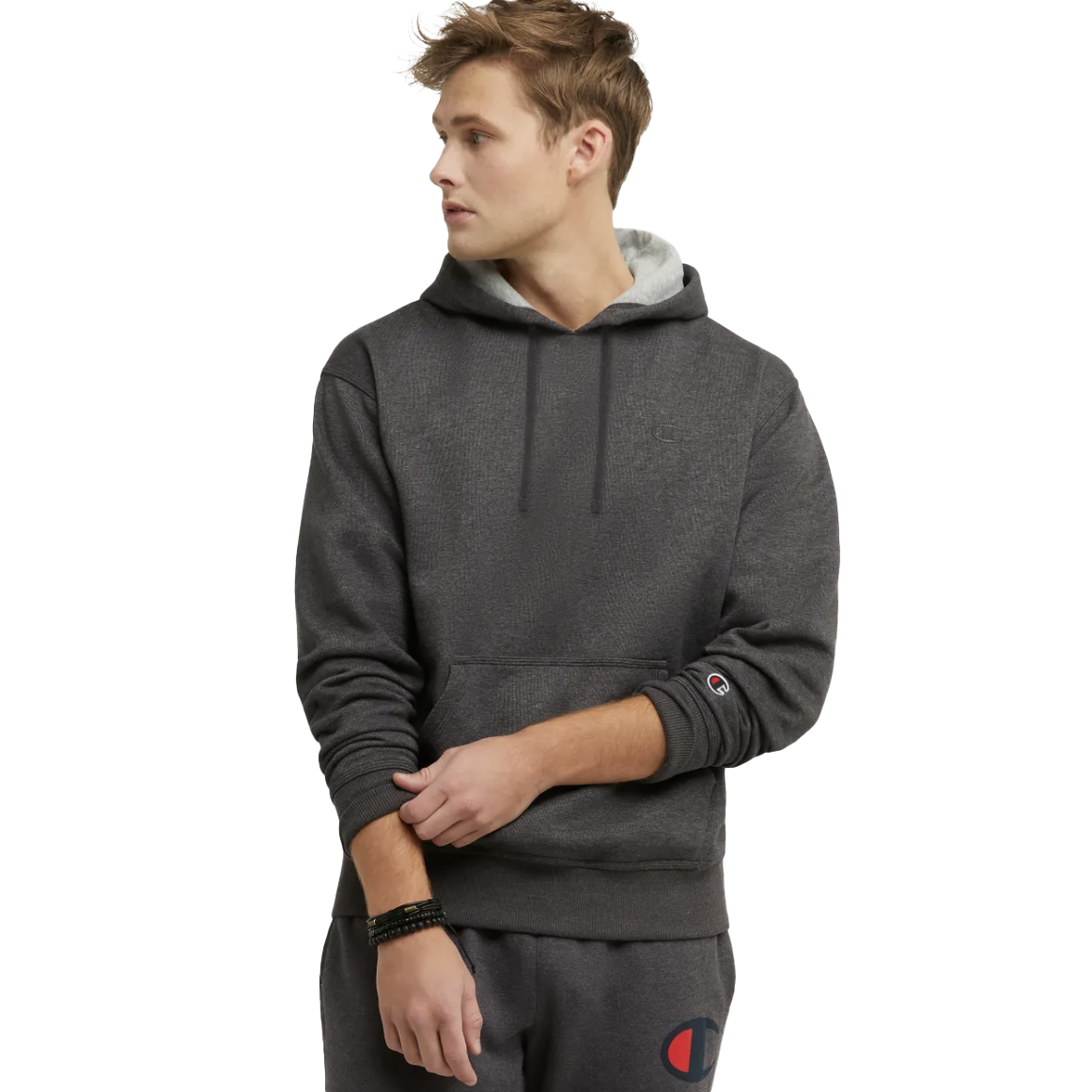 A man is wearing a gray Powerblend hoodie with a hood, long sleeves, and a small logo on the wrist. The hoodie has a relaxed fit and a kangaroo pocket.