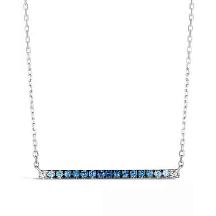 A silver necklace with a horizontal bar pendant featuring a gradient of small blue gemstones from light to dark.