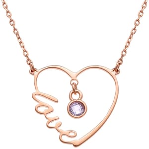 Rose gold-toned necklace with a heart-shaped pendant featuring the word \“love\“ incorporated into the design and a light purple gemstone hanging in the center.