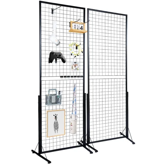 2-pack VEVOR Grid Wall Panels, each with a black metal wireframe design, featuring a variety of hanging items such as a light bulb, game controller, clipboard, and picture frame. Panels are freestanding with sturdy metal bases.