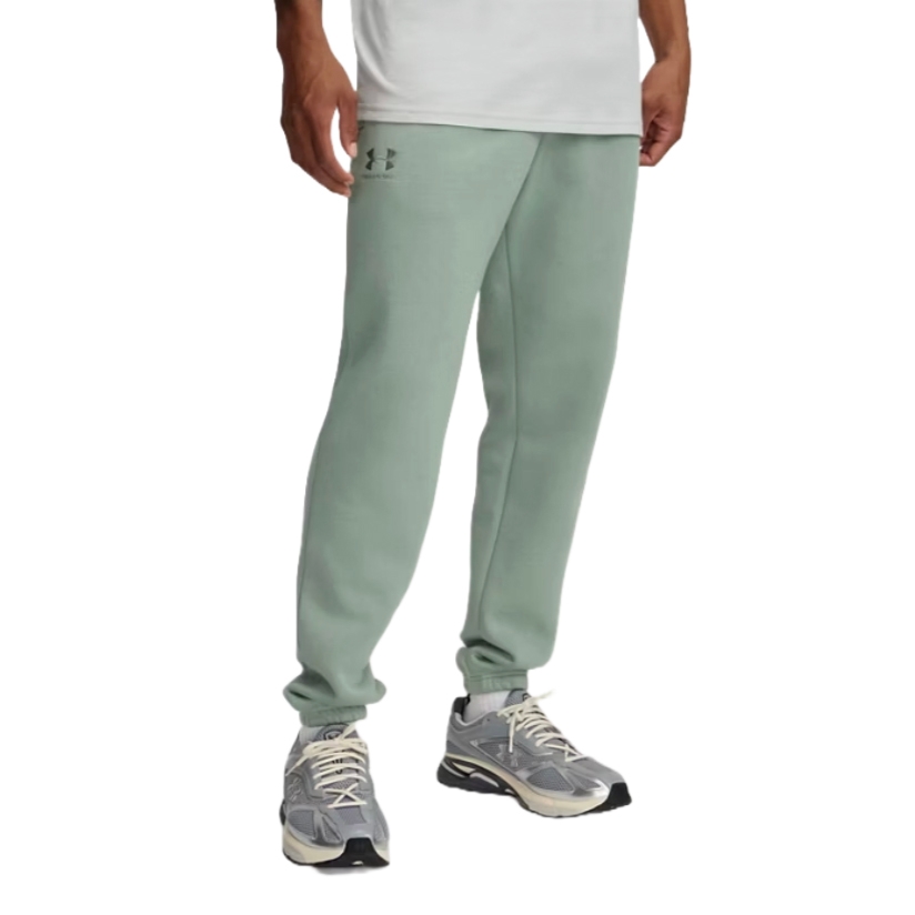 A person is wearing sage green jogger pants with an Under Armour logo and gray athletic sneakers.