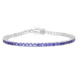 A silver tennis bracelet featuring a series of blue gemstones set in round links with a secure clasp closure.