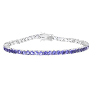 A silver tennis bracelet featuring a series of blue gemstones set in round links with a secure clasp closure.