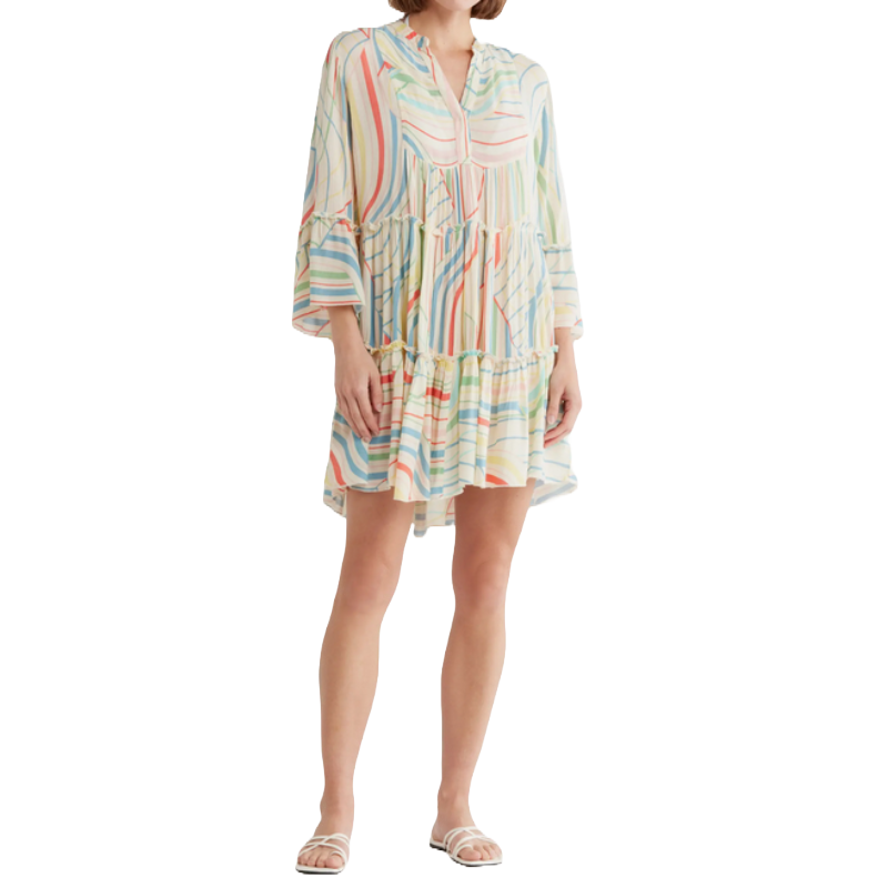 A woman is wearing a colorful, striped, knee-length dress with three-quarter sleeves and a ruffled hem, paired with white sandals.