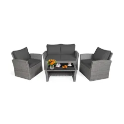 Outdoor patio furniture set with gray wicker and cushions includes a loveseat, two armchairs, and a coffee table with decorations like flowers, books, and snacks.