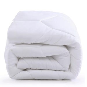 A neatly folded white mattress pad with a quilted design, suggesting a plush and comfortable texture.