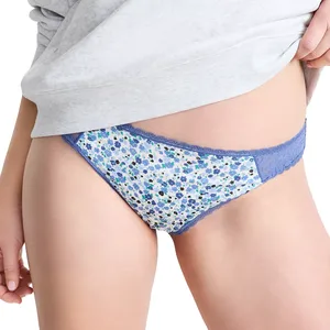 Blue floral lace-trimmed panties worn by a person, partially covered by a light gray top.