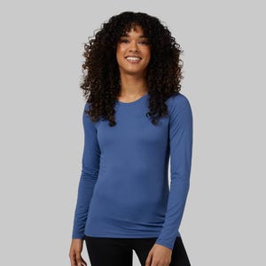 A woman wearing a blue long-sleeved athletic shirt.