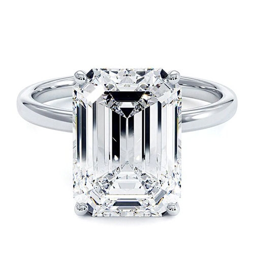 A platinum engagement ring with a large rectangular emerald-cut diamond set in a four-prong setting.