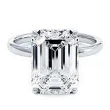 A platinum engagement ring with a large rectangular emerald-cut diamond set in a four-prong setting.