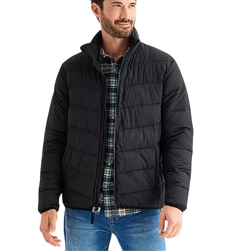 A man is wearing a black puffer jacket over a plaid shirt with blue jeans.