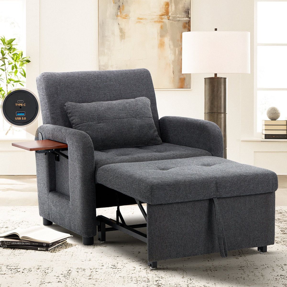 A gray reclining chair extends into a sleeper with an attached side tray and built-in USB Type-C and USB 3.0 ports. A textured pillow is included, and the setting features a modern lamp and abstract wall art.