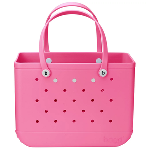 A pink tote bag with perforations, features \“b\“ logos on the handles, and a structured design.
