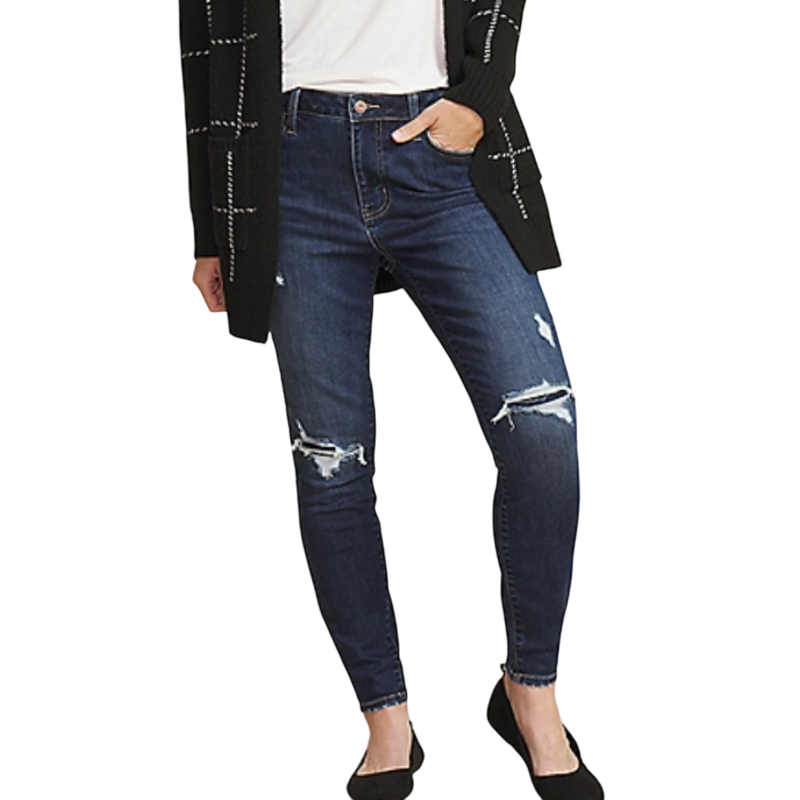 A person is wearing dark blue distressed skinny jeans paired with a black cardigan featuring white grid patterns and black flats.