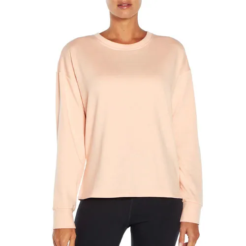 A light pink, long-sleeve pullover with a relaxed fit and crew neckline, paired with dark pants.