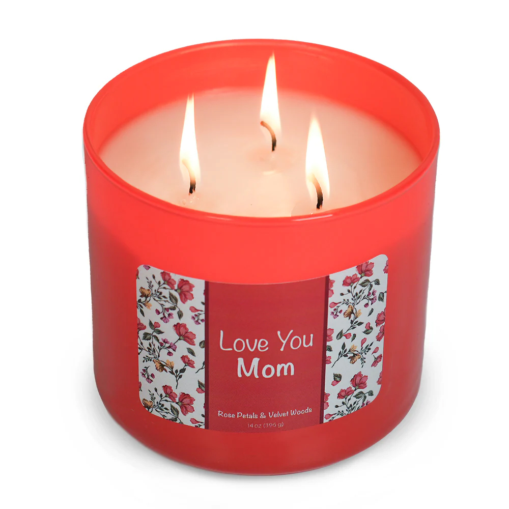 Red, three-wick candle labeled \“Love You Mom\“ with a floral border, scented with rose petals and velvet woods.