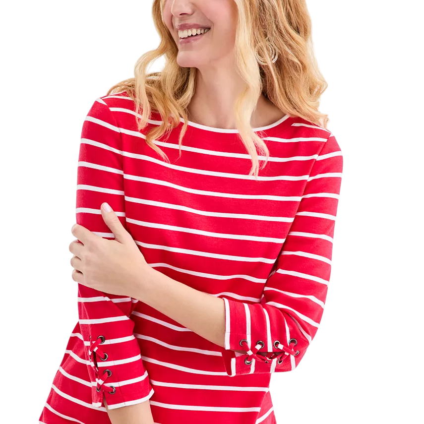 A woman is wearing a red and white striped top with lace-up details on the sleeves.