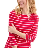 A woman is wearing a red and white striped top with lace-up details on the sleeves.
