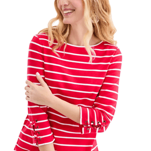 A woman is wearing a red and white striped top with lace-up details on the sleeves.
