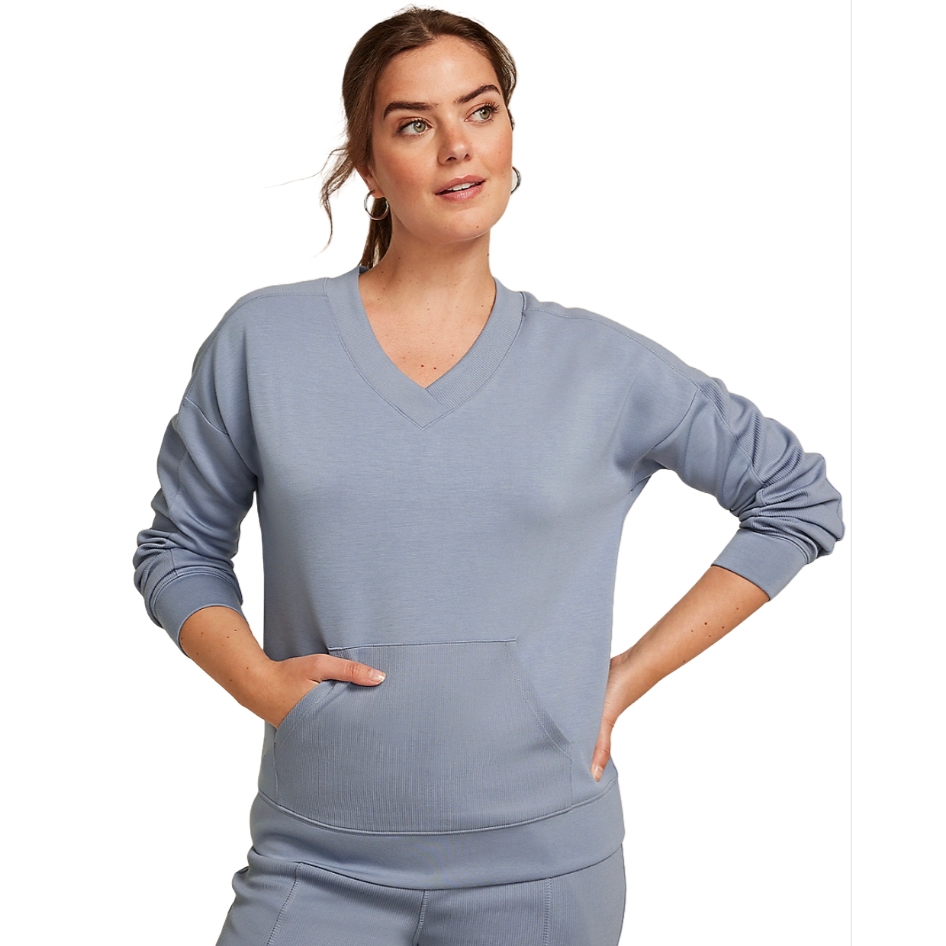 A woman is wearing a light blue V-neck sweatshirt with long sleeves and a front pocket.