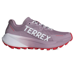 A pink and red trail running shoe with \“TERREX\“ branding, featuring a thick, textured sole for grip and \“LIGHTSTRIKE\“ cushioning technology.