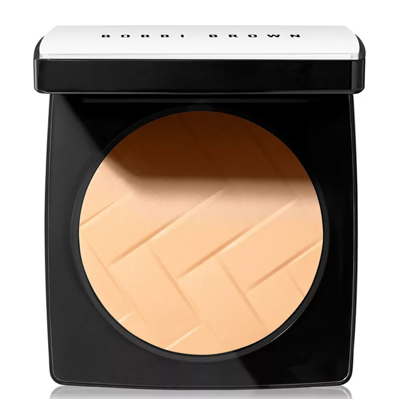 Compact powder in a black and silver case with a textured surface, labeled \“Bobbi Brown.\“
