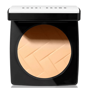 Compact powder in a black and silver case with a textured surface, labeled \“Bobbi Brown.\“