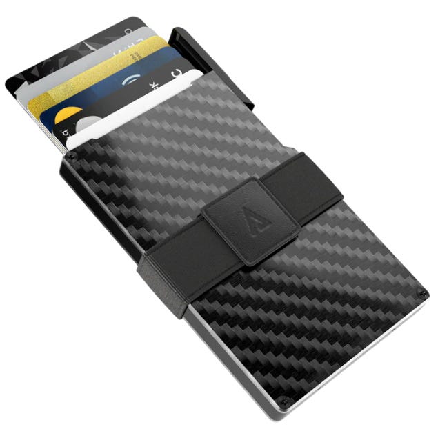 A carbon fiber minimalist wallet with elastic strap holding multiple cards.