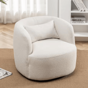 A cozy, white, rounded armchair with a textured fabric and a matching pillow, placed on a light brown carpet next to a bookshelf.