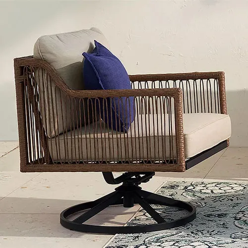 A swivel outdoor armchair with wicker sides, beige cushions, and a blue throw pillow.