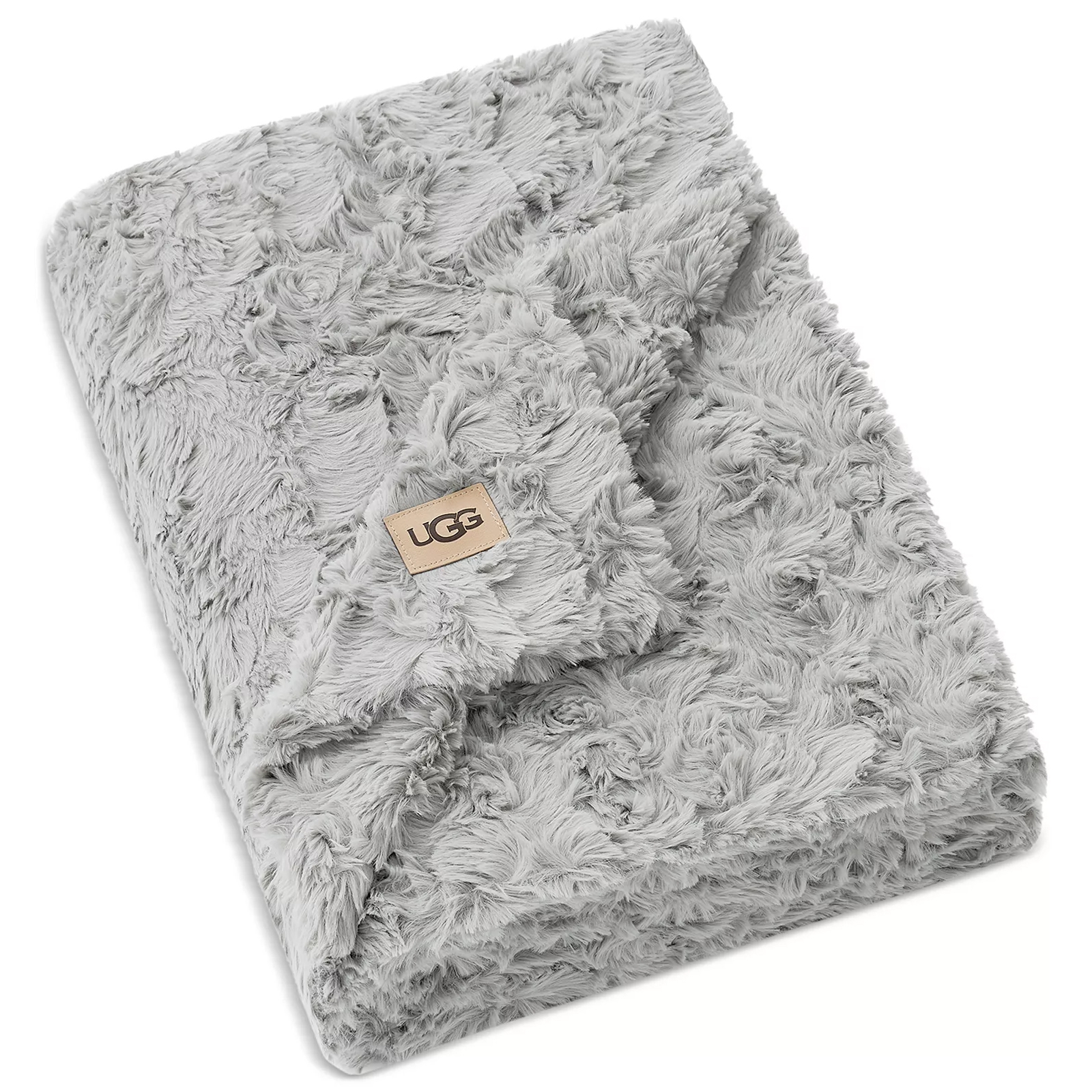 A soft, grey faux fur blanket with the UGG logo on a tan patch, featuring a textured, plush design.