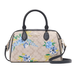 Kate Spade large floral duffle bag features a beige background with blue and green floral patterns, black handles, and a detachable shoulder strap. The bag has gold-tone hardware and \“kate spade NEW YORK\“ branding.