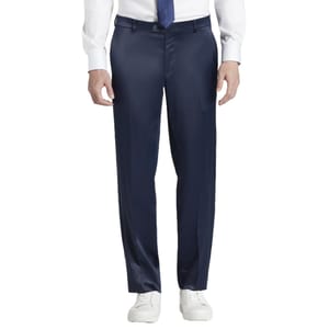 Man wearing navy dress pants with a white dress shirt, navy tie, and white sneakers.